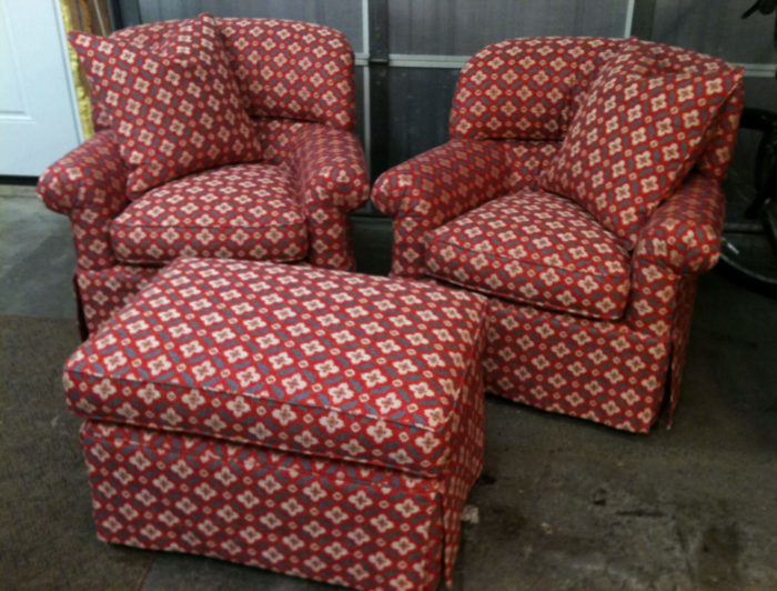 Red, patterned living room chairs and an ottoman