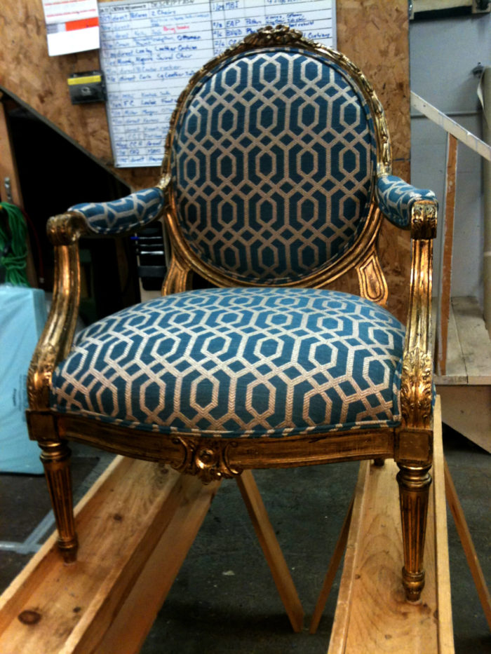 Newly reupholstered chair from Hanover resting on workshop beams