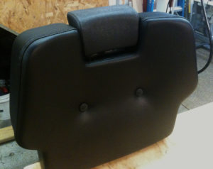 Black barber chair head-rest sitting in workshop